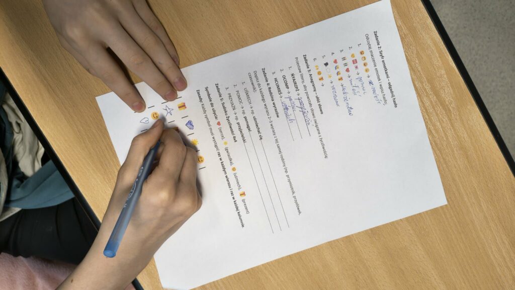 widzimy kartę pracy i ręce dzieci które ją wykonują