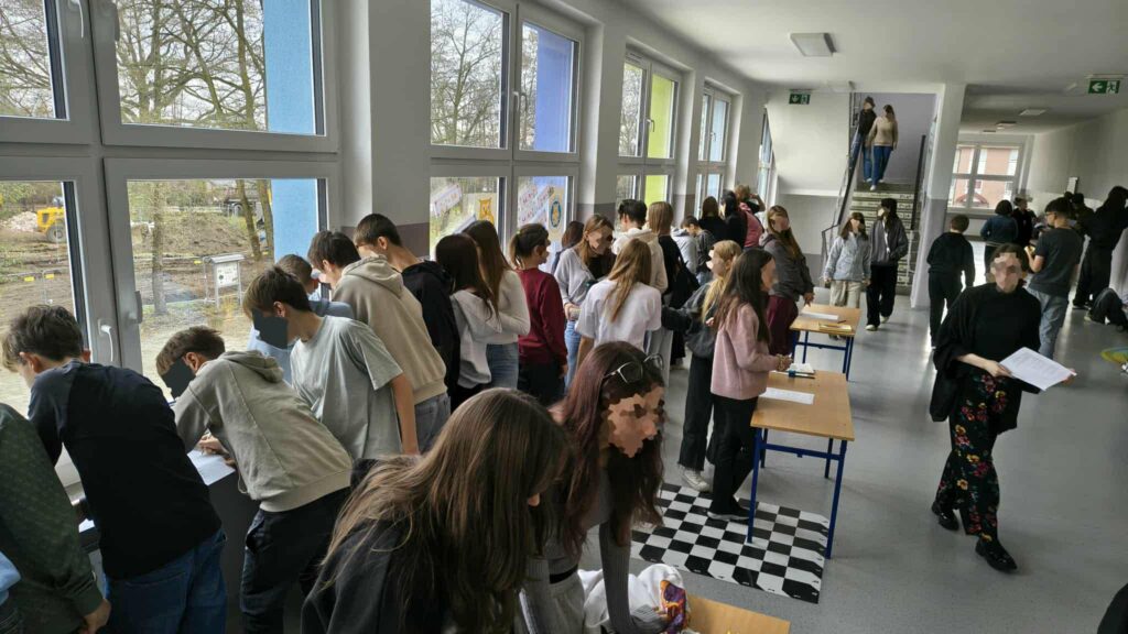 widzimy dzieci które  wykonują karty pracy na parapetach 