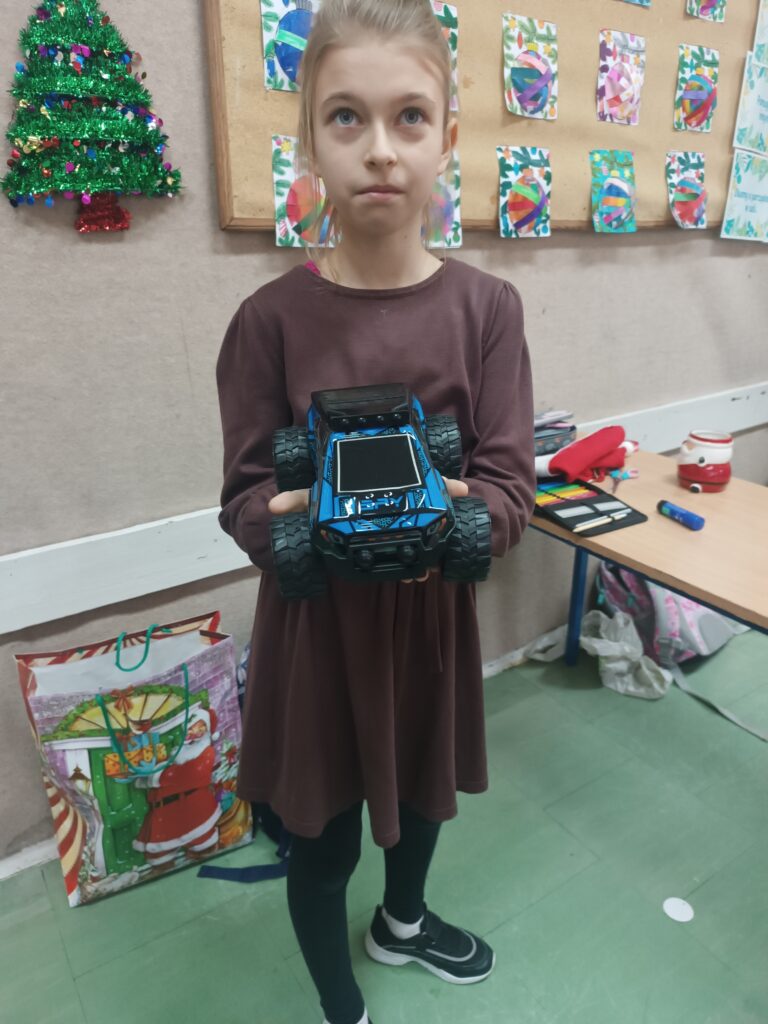 dziewczynka pokazuje samochód niebieski