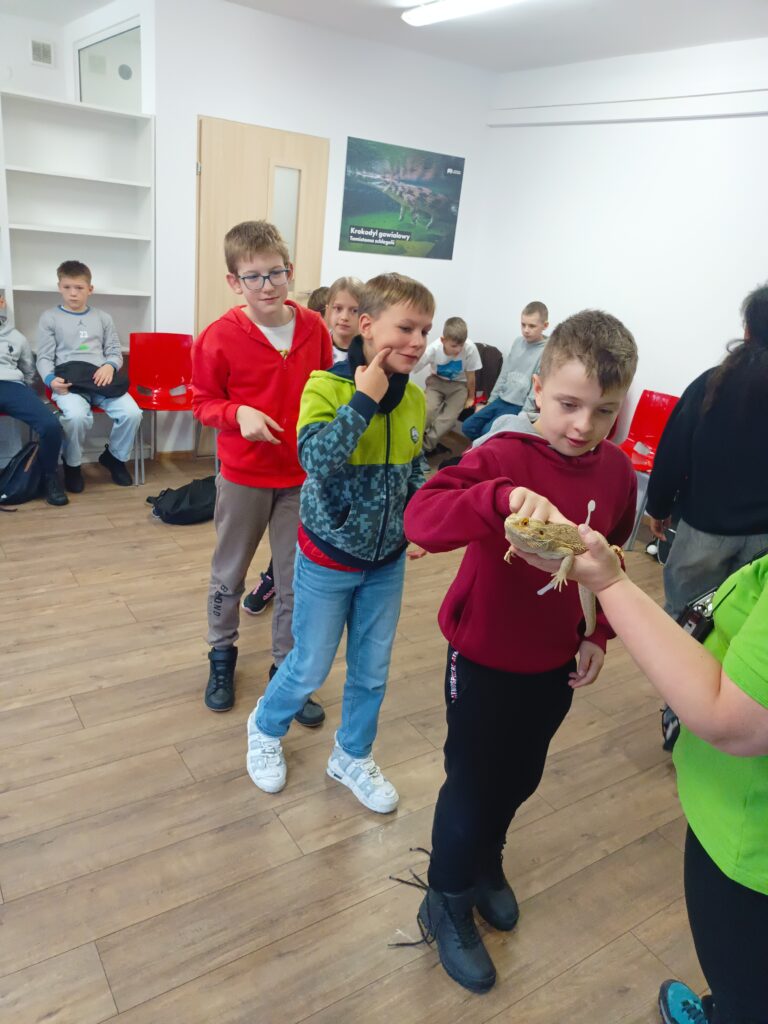 zdjęcie grupowe uczniów  tańczących w sali klasowej