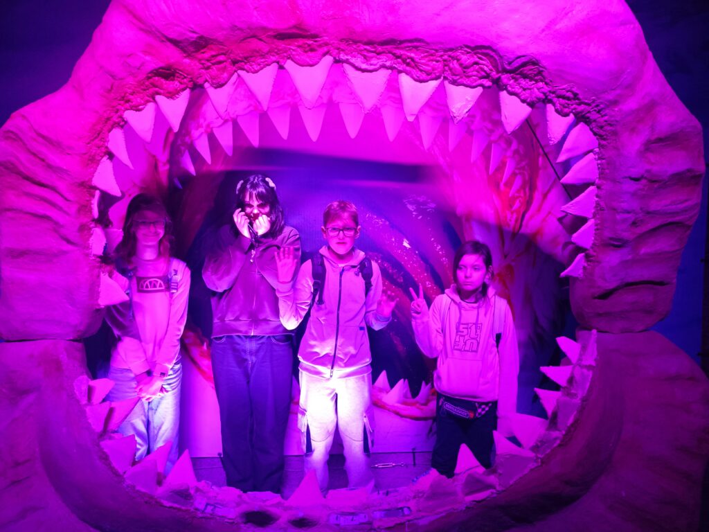 zdjęcie grupowe uczniów stojących w szczęce sztucznej wieloryba