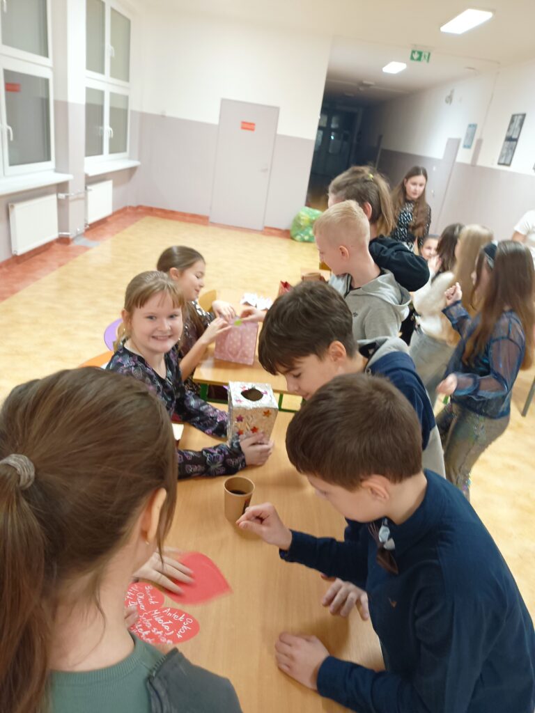 zdjęcie grupowe uczniów  pracujących w ławkach z papierem