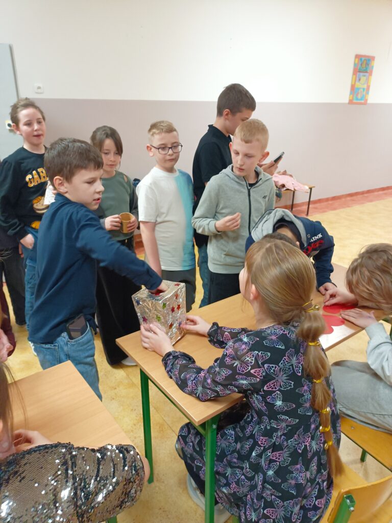 zdjęcie grupowe uczniów stojących przed ławką z uczennicą