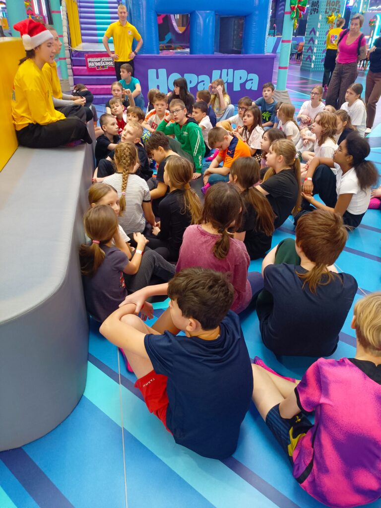 zdjęcie grupowe uczniów  siedzących na materacach