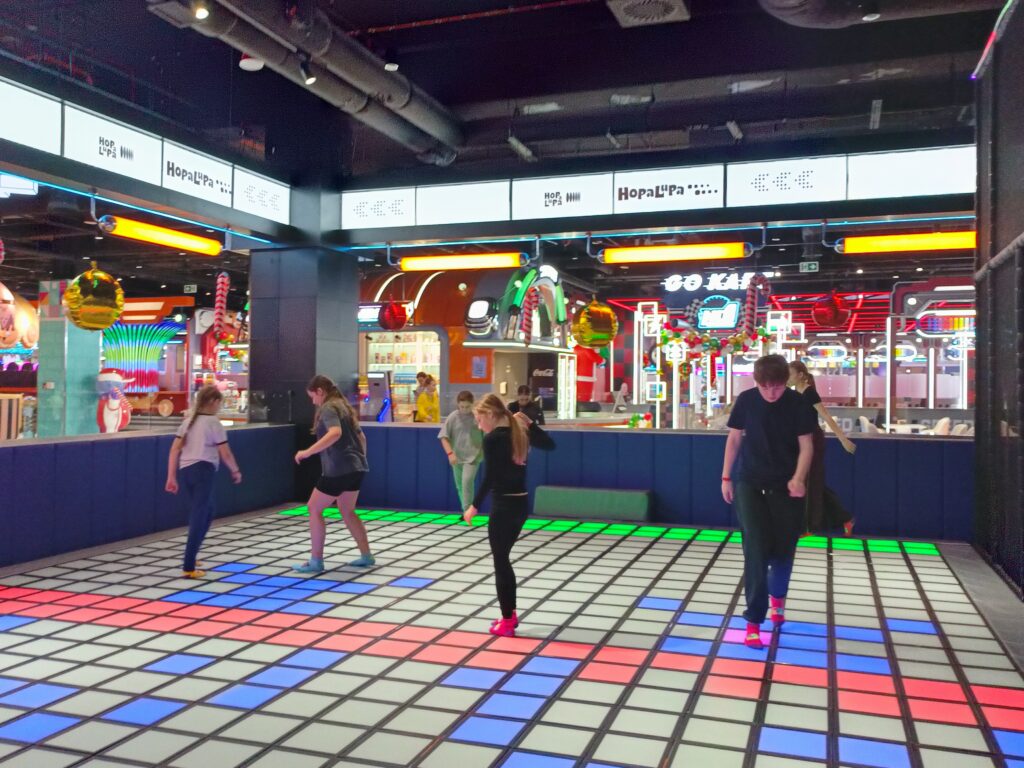 zdjęcie grupowe uczniów bawiących się na kolorowej podłodze