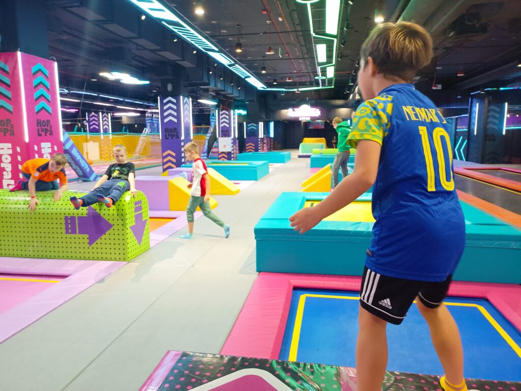 zdjęcie grupowe uczniów skakających na trapolinach