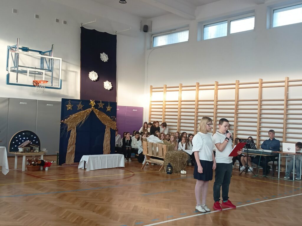 dwoje uczniów stoi z przodu i przemawia