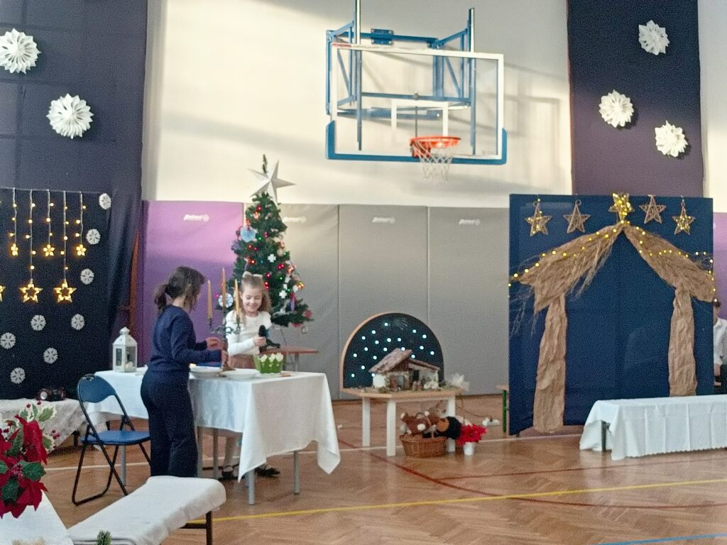 dwie dziewczynki stoją przy ławce przybranej białym materiałem 