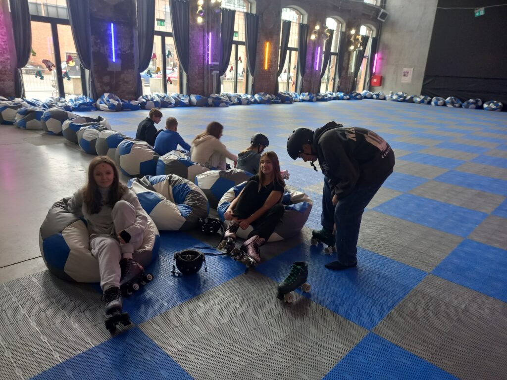 Dzieci siedzą na poduszko-fotelach.