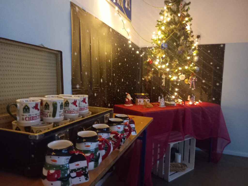 zdjęcie koszyka wiklinowego, kubeczków świątecznych, w tle choinka