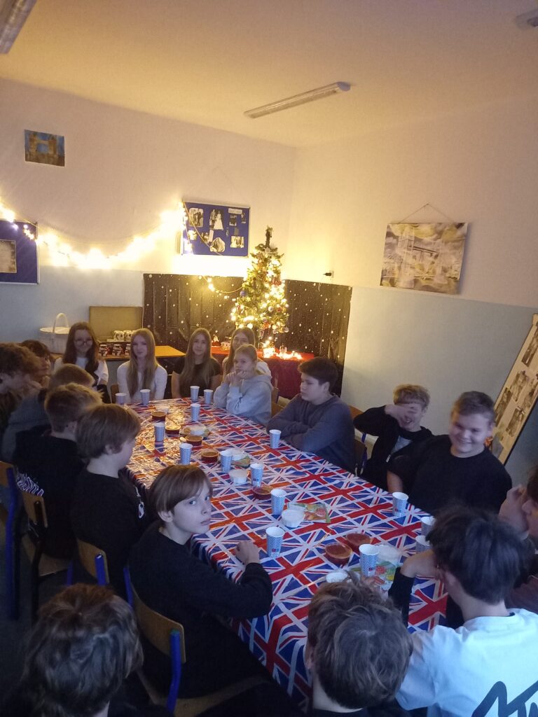 dzieci siedzą przy stoliku, w tle choinka