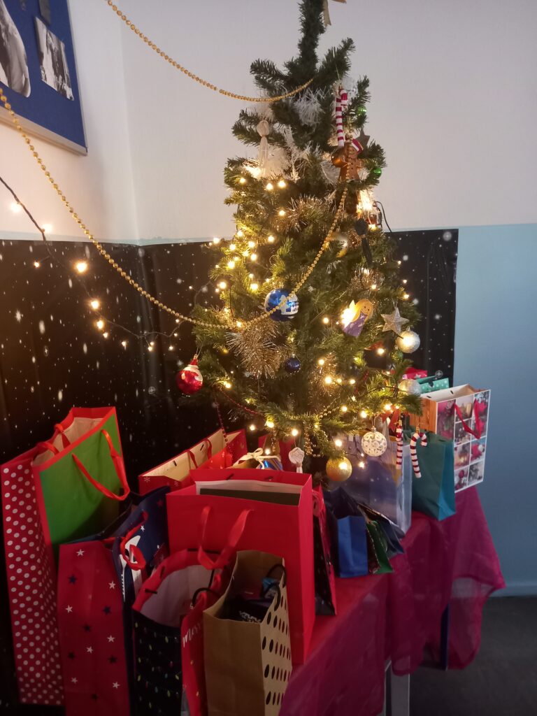 choinka z prezentami na czerwonym materiale