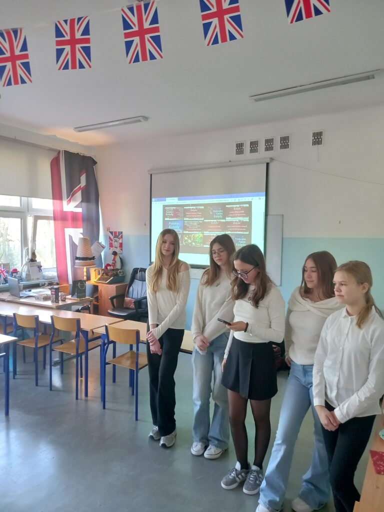 stoją dziewczynki za nimi ekran wyświetla piosenki