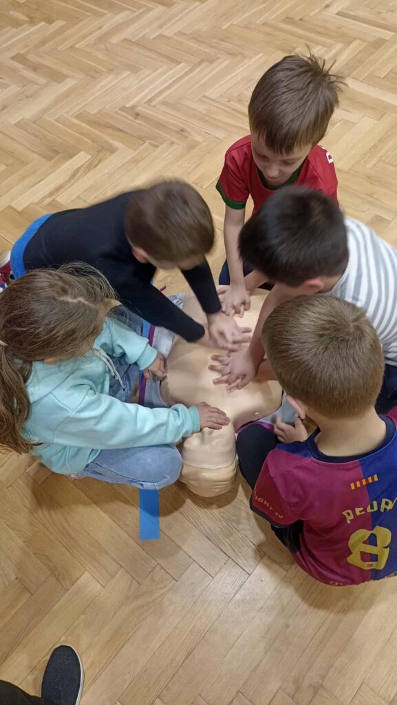 uczniowie ćwiczą na fantomie pierwszą pomoc.