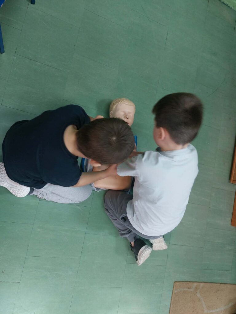 uczniowie ćwiczą na fantomie pierwszą pomoc.