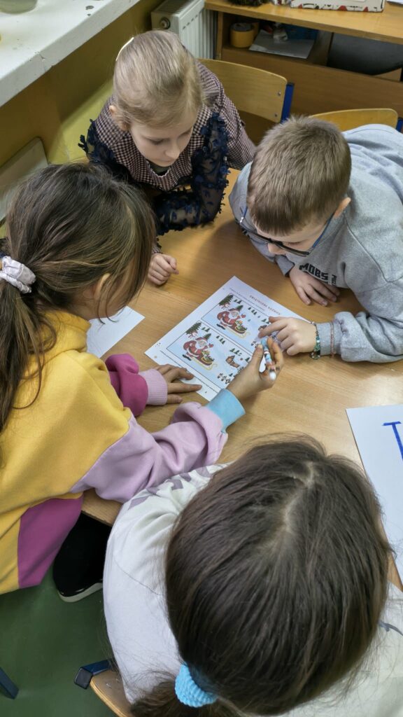 dzieci wspólnie rozwiązują kartę pracy