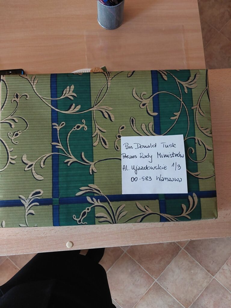 Na zdjęciu widoczna jest zaadresowana paczka z kartkami świątecznymi do Premiera od uczniów SP182. 