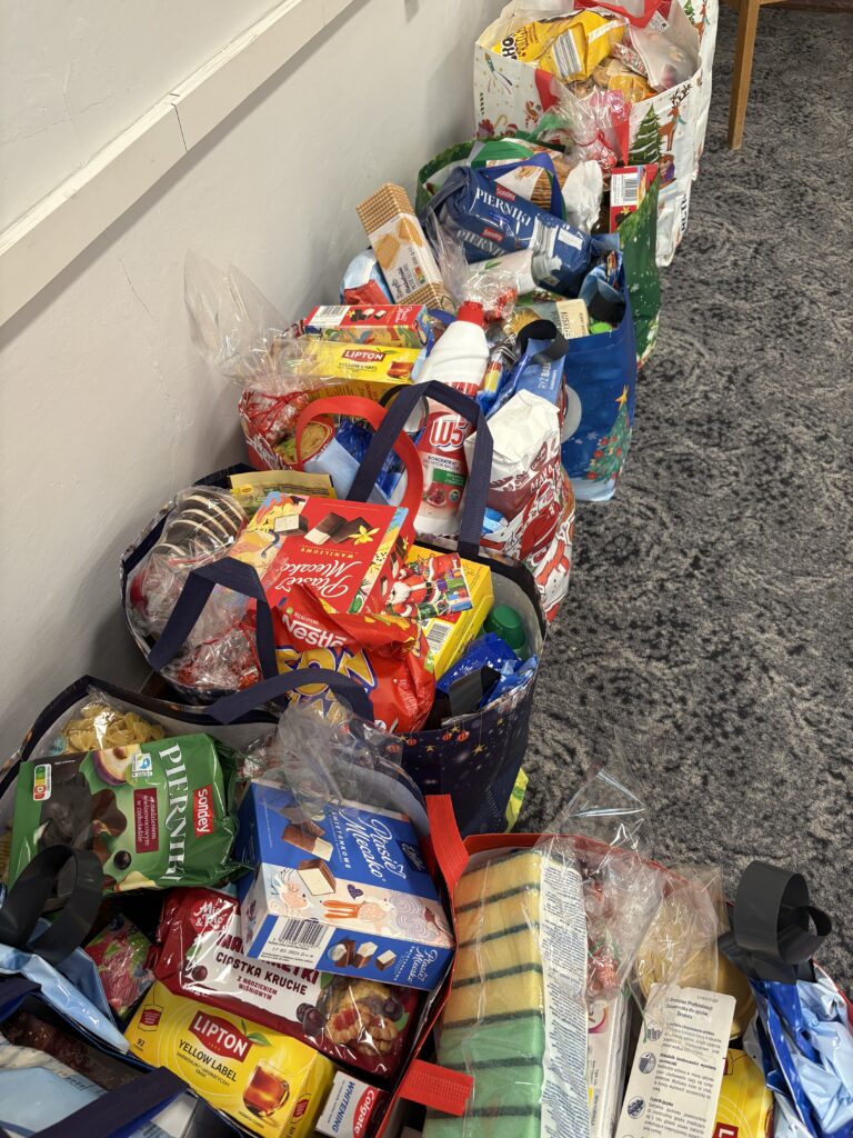 zdjęcie kolorowych reklamówek wypełnionych różnymi darami. Takimi jak herbata, ryż, kasza, słodycze, olej itp.