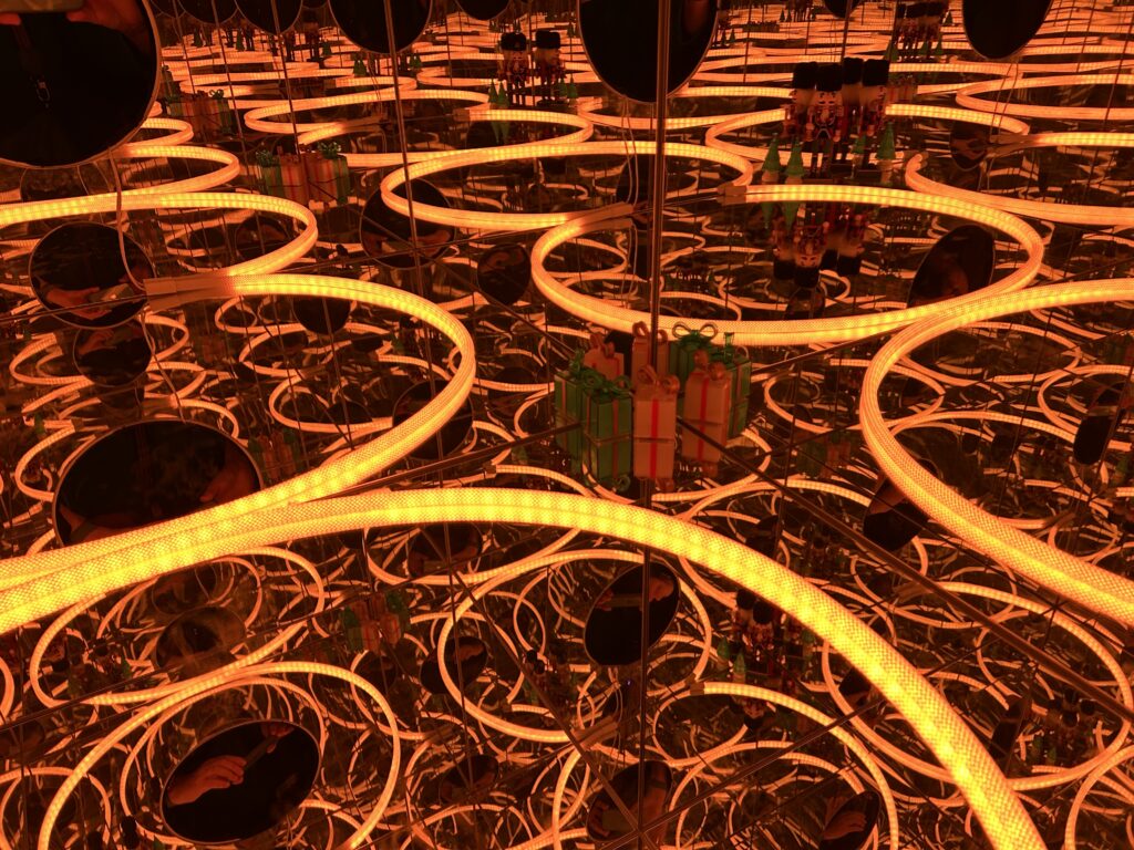 kółka zółte i pomarańczowe , w środku obrazka małe pudełka zapakowane jak prezenty w kolorze zielonym i pomarańczowym, w głębi widać ustawione figurki dawnych żołnierzy