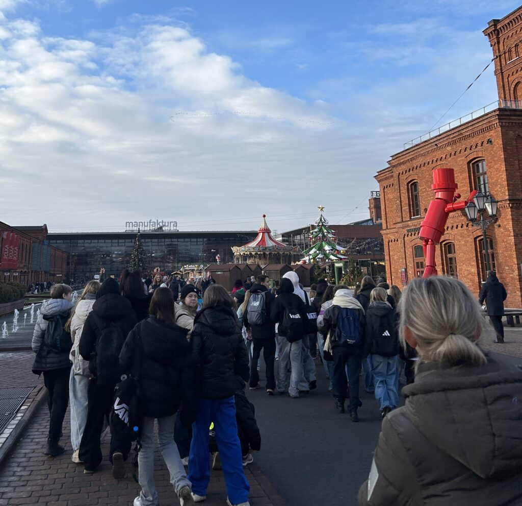 na rynku w Manufakturze, idzie grupa dzieci, przyglądają się dekoracjom świątecznym
