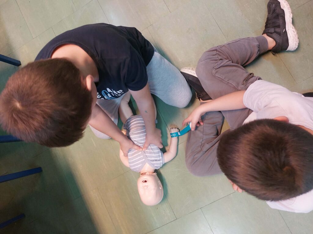 uczeń ćwiczy na fantomie pierwszą pomoc.