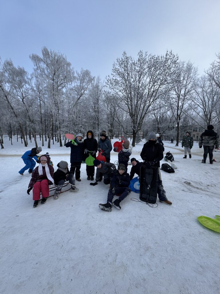Uczniowie klasy 4b podczas wfu na śniegu zjeżdżają z górki.