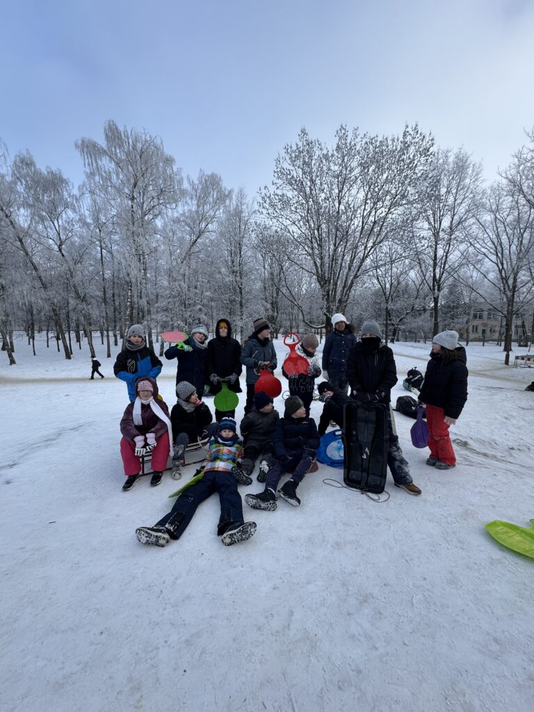 Uczniowie klasy 4b podczas wfu na śniegu zjeżdżają z górki.