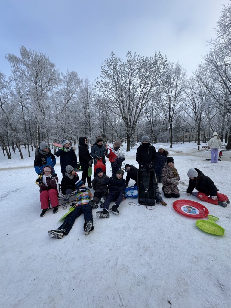 Uczniowie klasy 4b podczas wfu na śniegu zjeżdżają z górki.