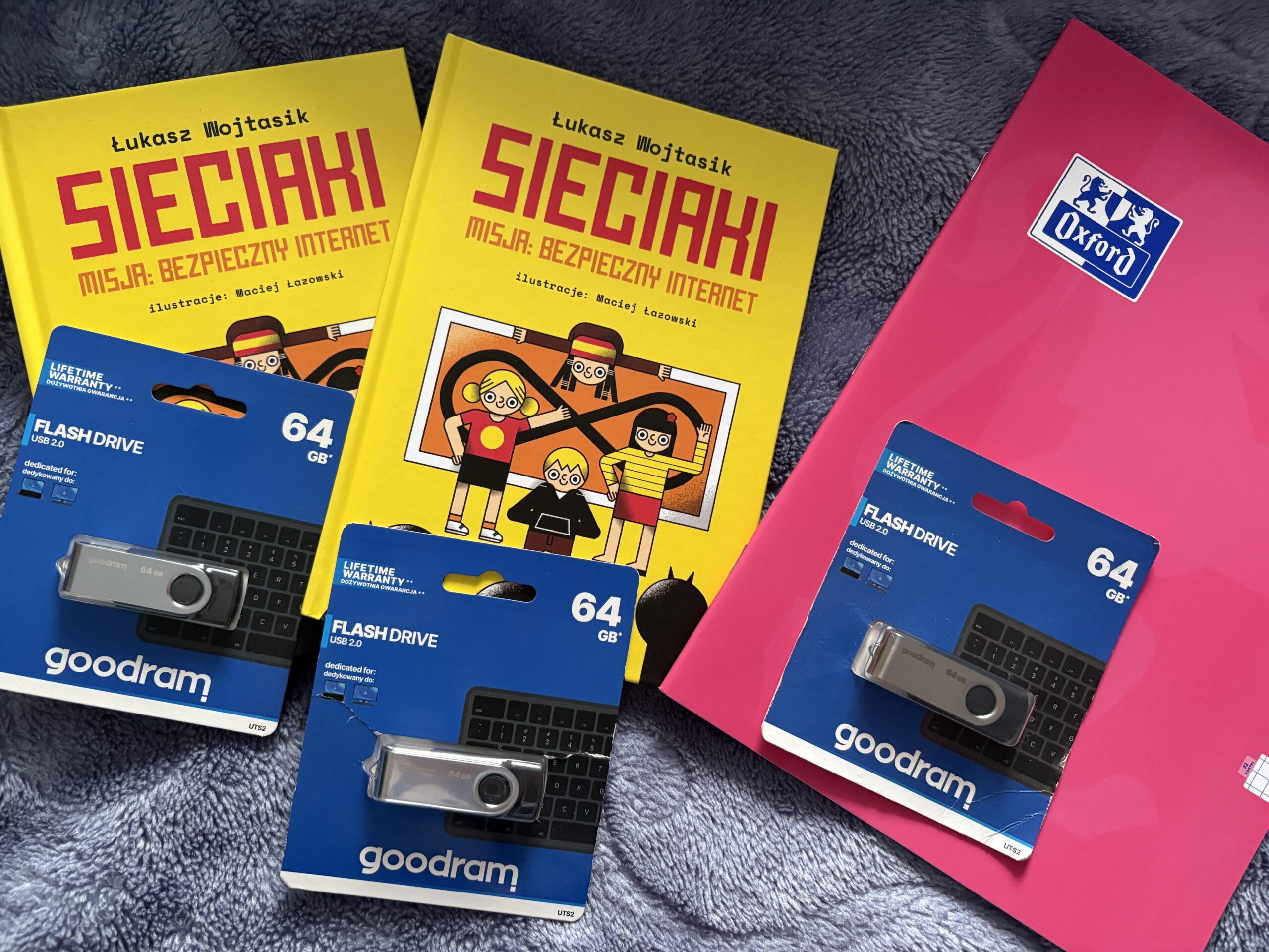 dwie książki  zeszyt i pendrive trzy