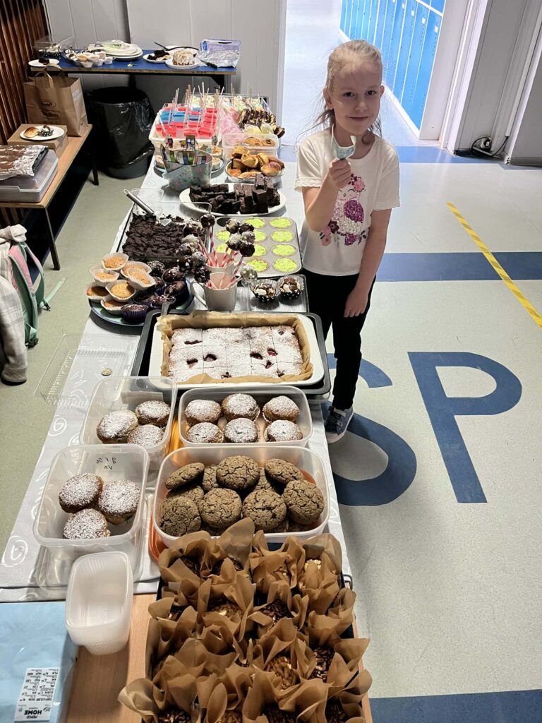 stuł ze słodyczami i dziewczynka stoi obok