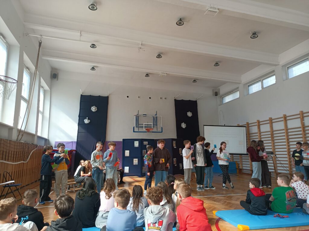 uczniowie stoją i mówią podczas przedstawienia