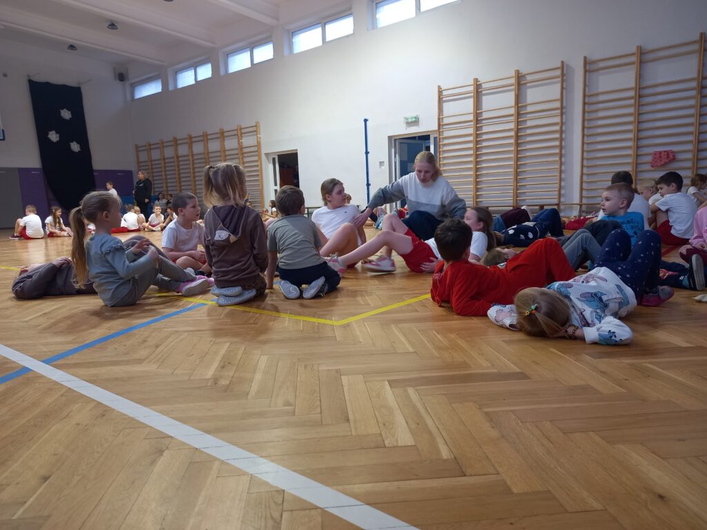 nauczycielka coś tłumaczy dzieciom