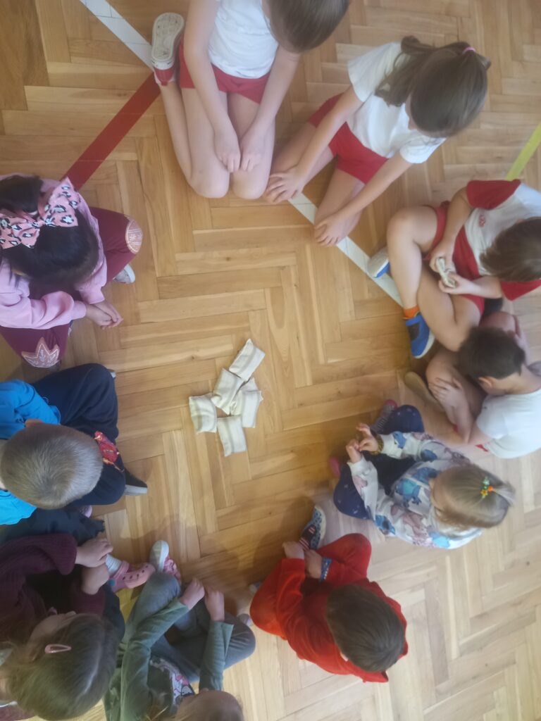 dzieci siedzą w kole 