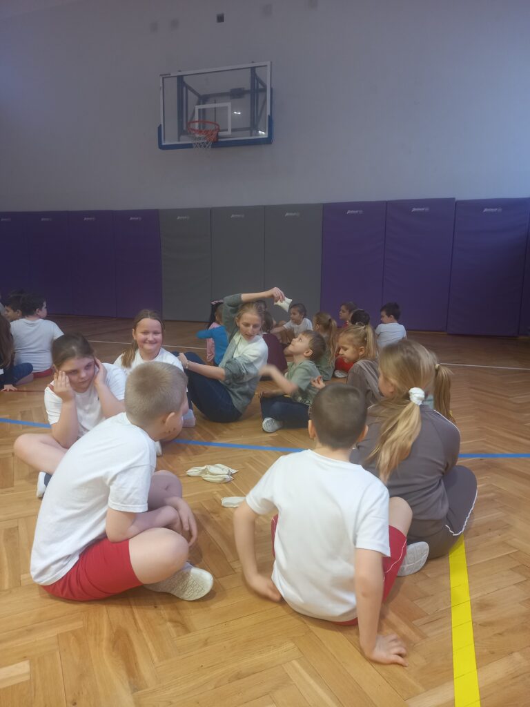 dzieci bawią się na sali gimnastycznej siedzą