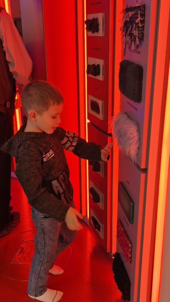 Uczeń dotyka płytek z różnymi fakturami.