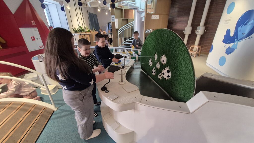 Uczniowie wykonują eksperyment z piłkami do piłki nożnej w EC1