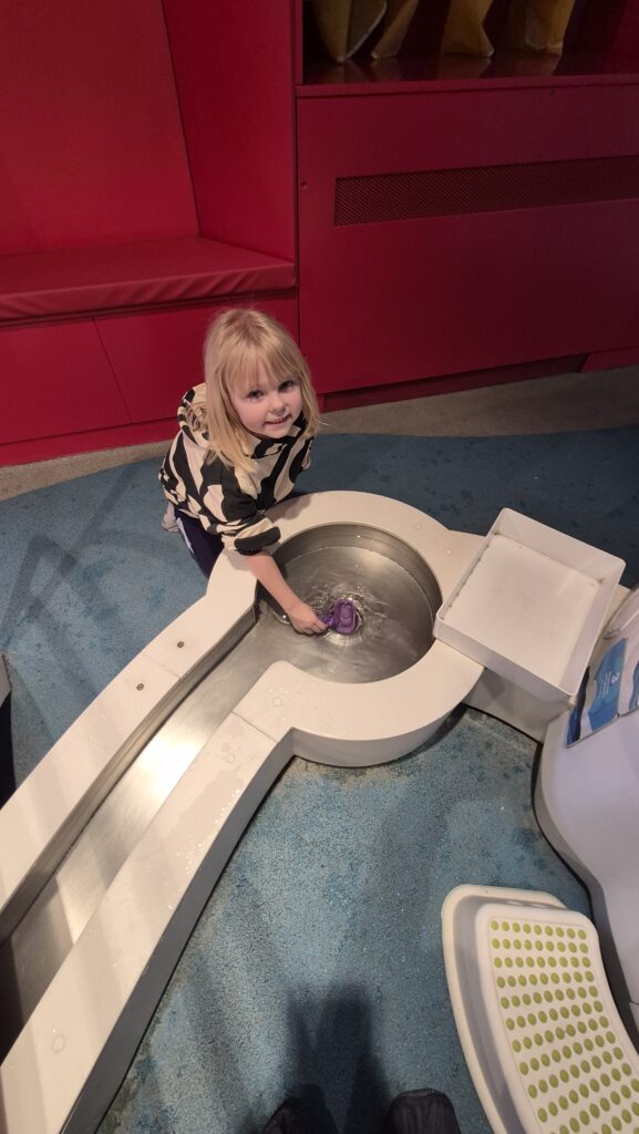 Uczennica przeprowadza eksperyment podczas wycieczki do EC1