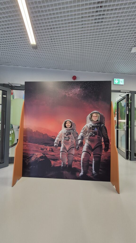 Plansza do robienia zdjęć przedstawiająca dwóch kosmonautów z głowami uczennic klas 1b/1d