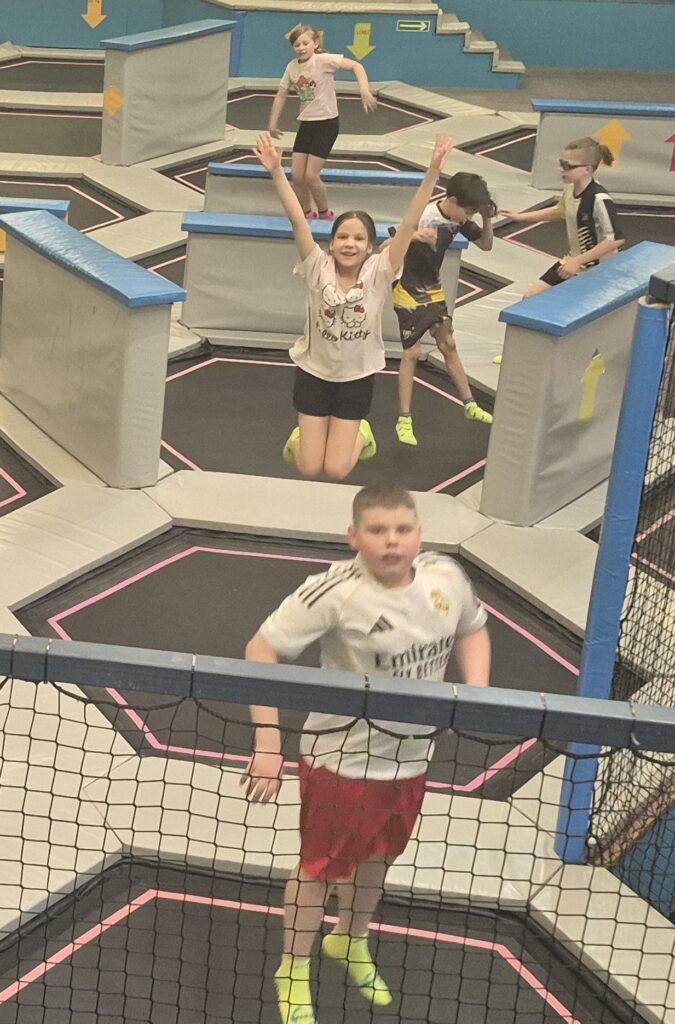 Uczniowie 4a skaczą na trampolinach w Saltosie.