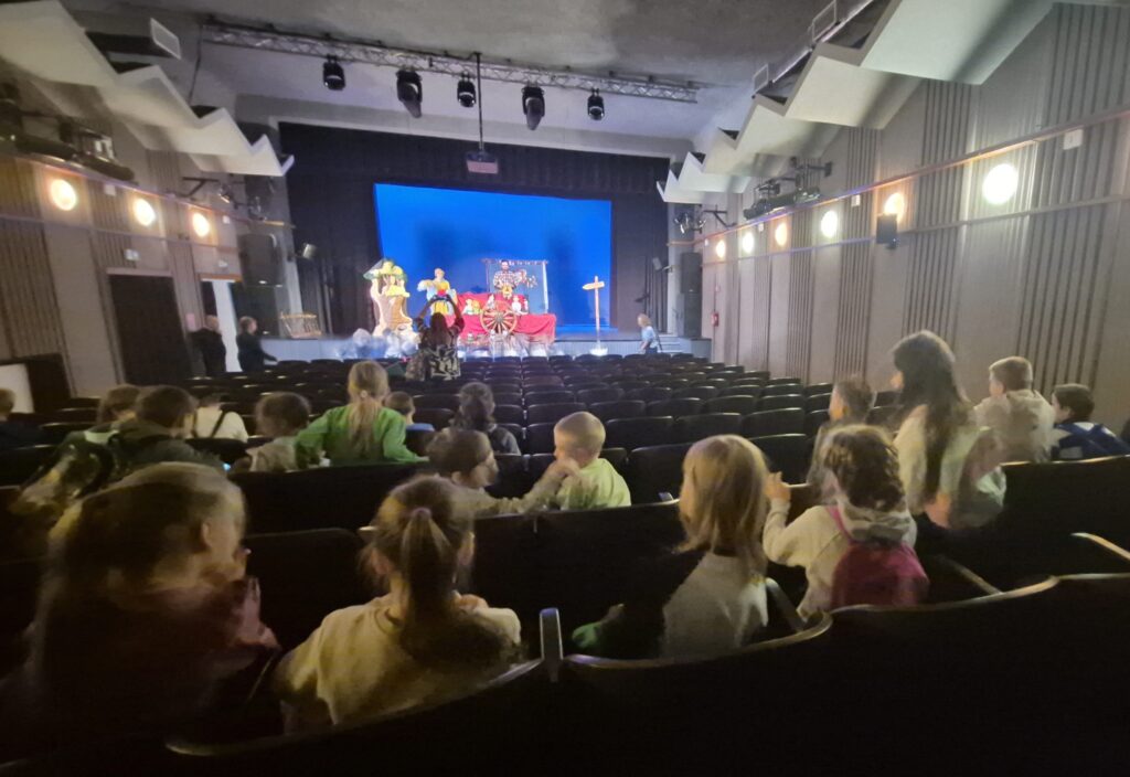 widać dzieci siedzące w teatrze