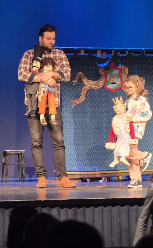 aktor trzyma kukiełki bkok dziewczynka trzyma kukiełkę 