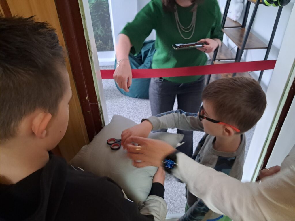 Zdjęcie przedstawia ucznia i dyrektora, którzy przygotowują się do przecięcia wstęgi.