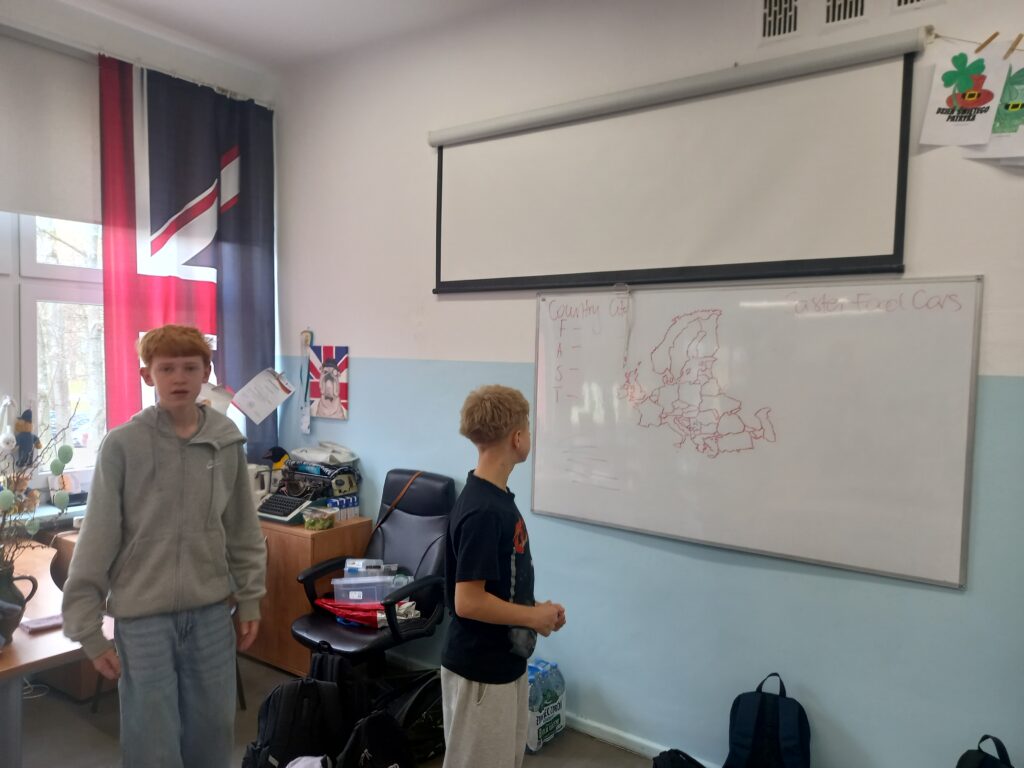 dwoje uczniów stoi przy mapie