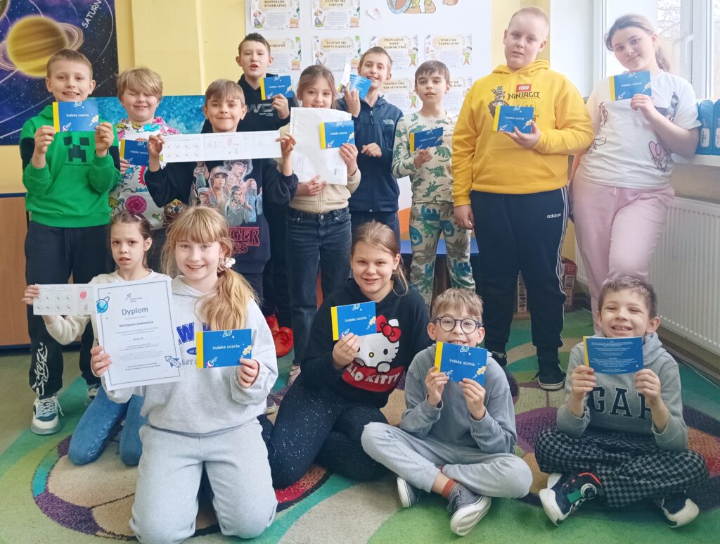 zdjęcie całek klasy, dzieci trzymają indeksy w rękach
