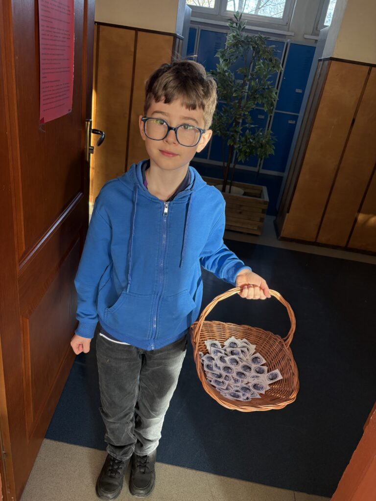 chłopiec trzyma kosz z naklejkami