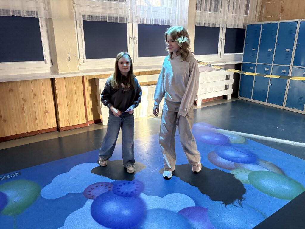 dziewczynki bawią się na dywanie interaktywnym 