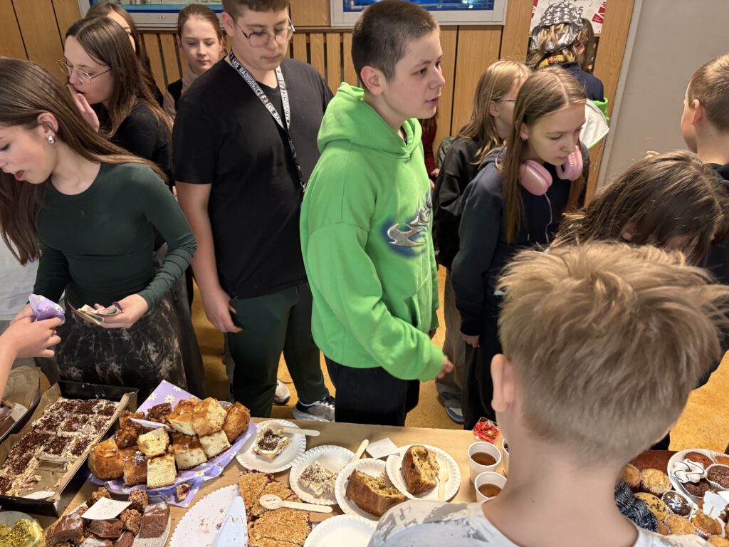 widać dzieci kupujące i stoliki ze słodkościami