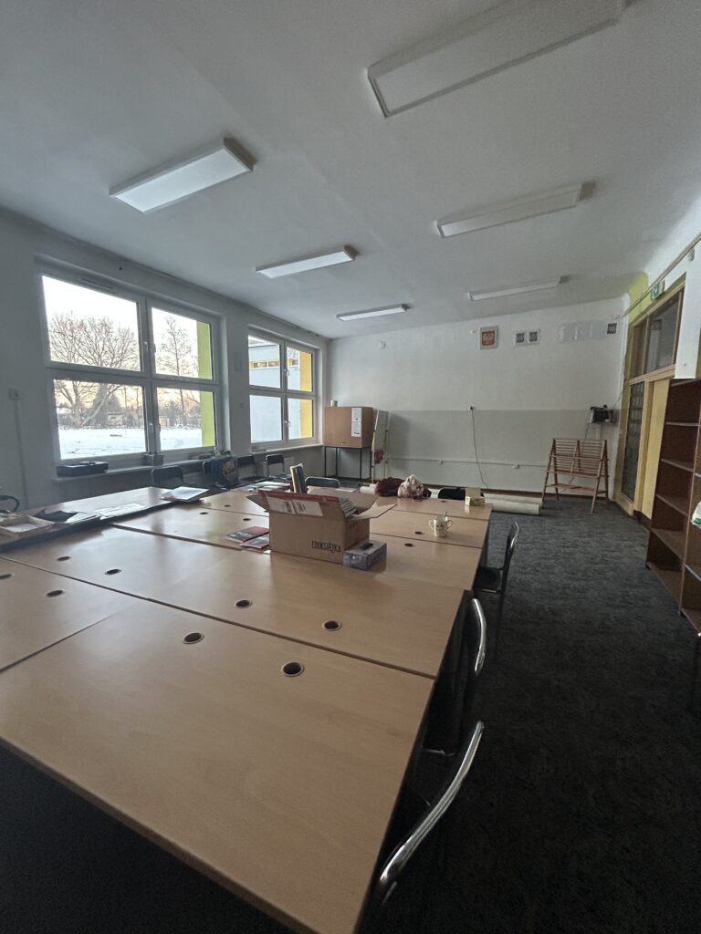 widok biblioteki przed remontem-pozsuwane stoły, ciemna wykładzina