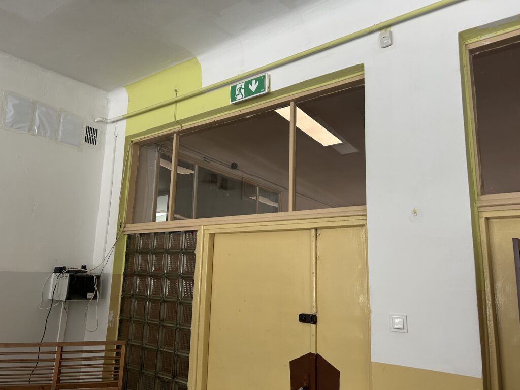 widok na drzwi biblioteki i kolorowe biało - zielone ściany