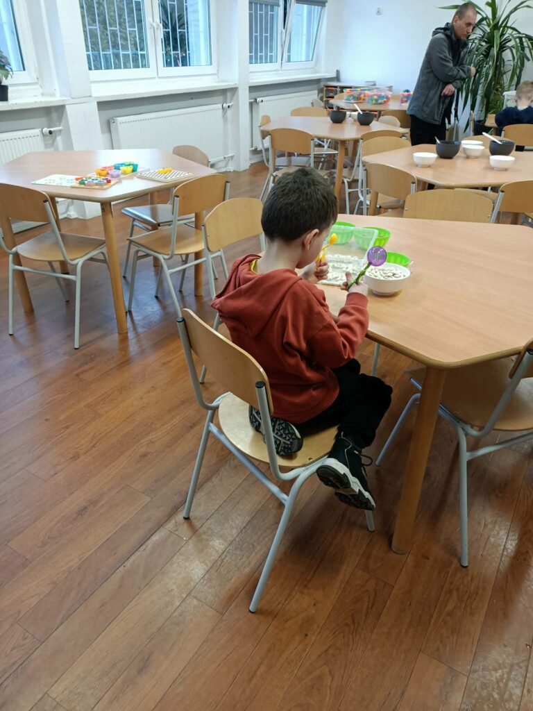 chłopiec siedzdzi przy stoliku